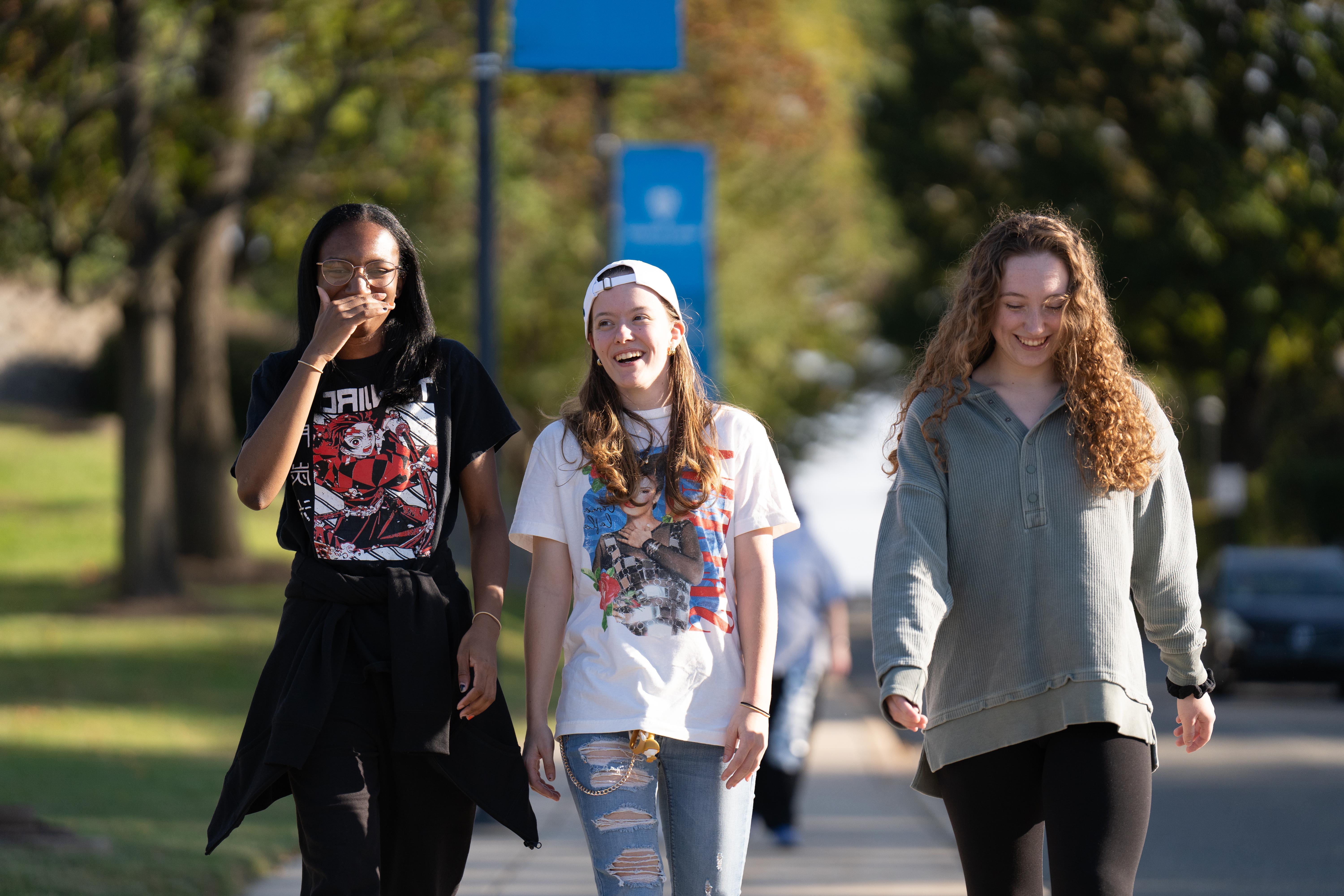 Three HFU students walking down a path on campus